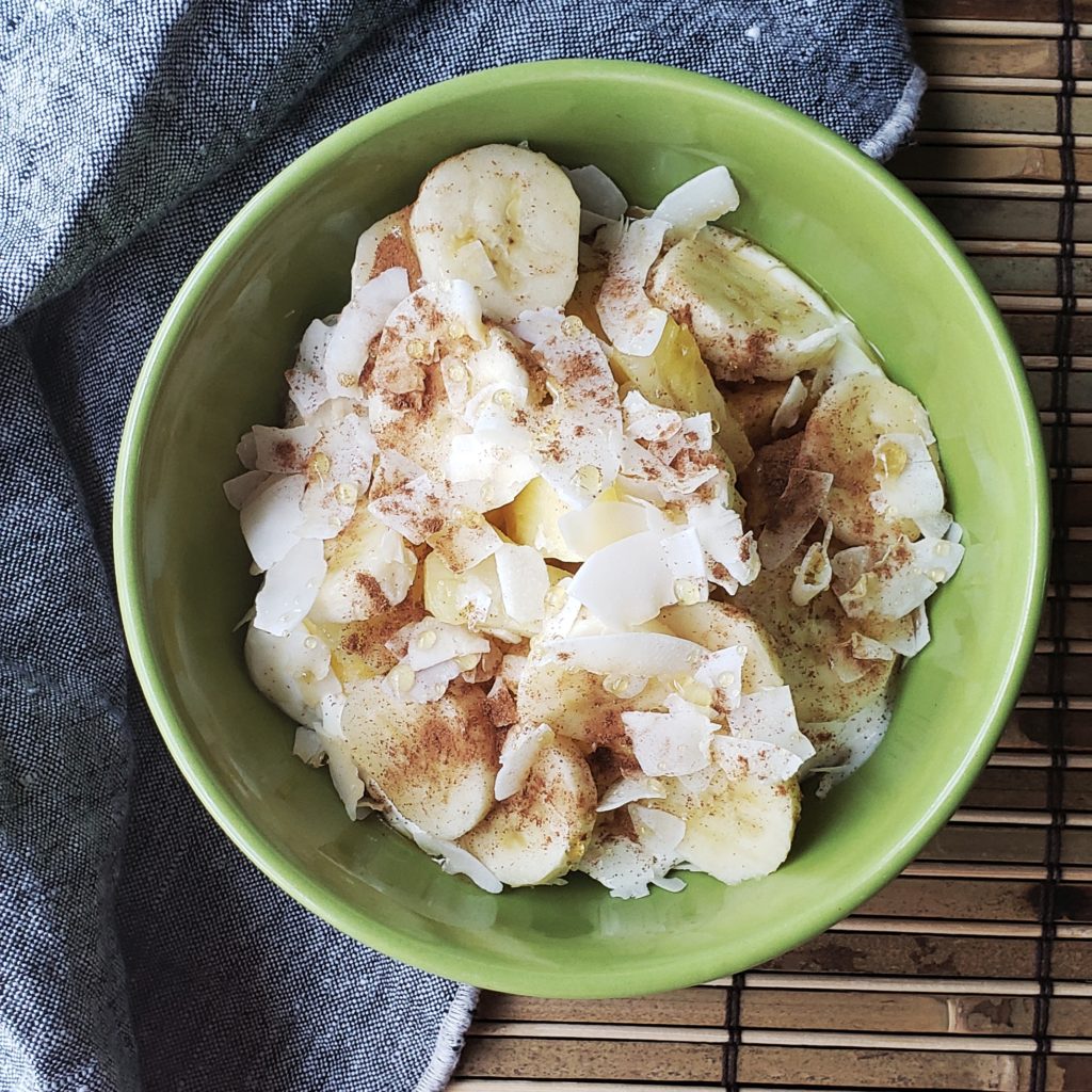 A refreshing bowl of Greek yogurt pilled high with tropical fruits and sprinkled with a dash of cinnamon and a drizzle of honey.